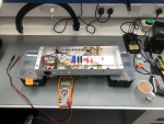 The open chassis of the valve amplifier sits on a workbench, next to which sits a multimeter and a fresh cup of tea.