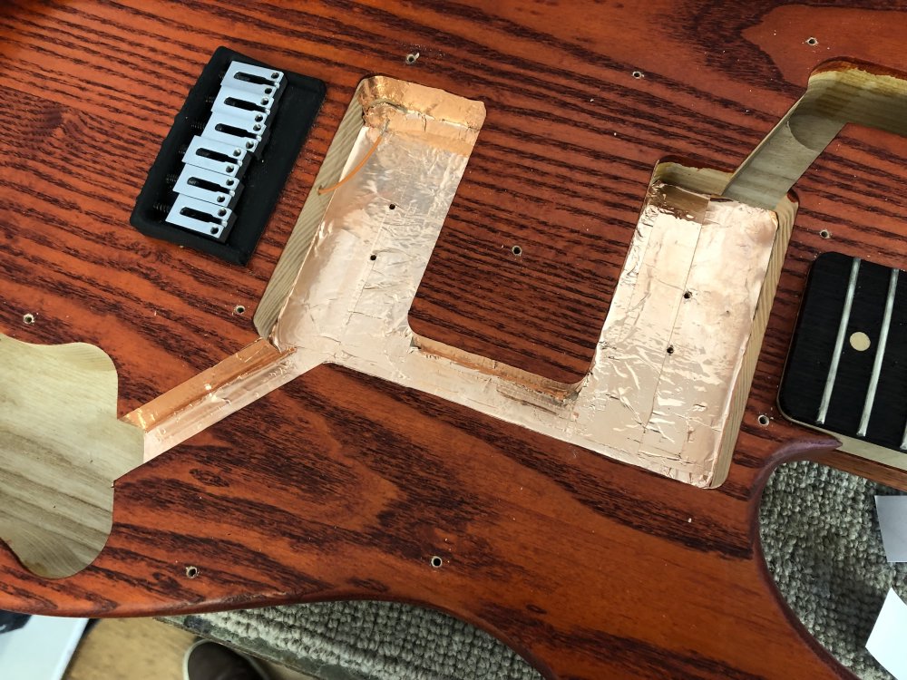 A later view of the same guitar body as in the previous picture, only now some of the cavities have shiny new copper tape and some are just bare wood.