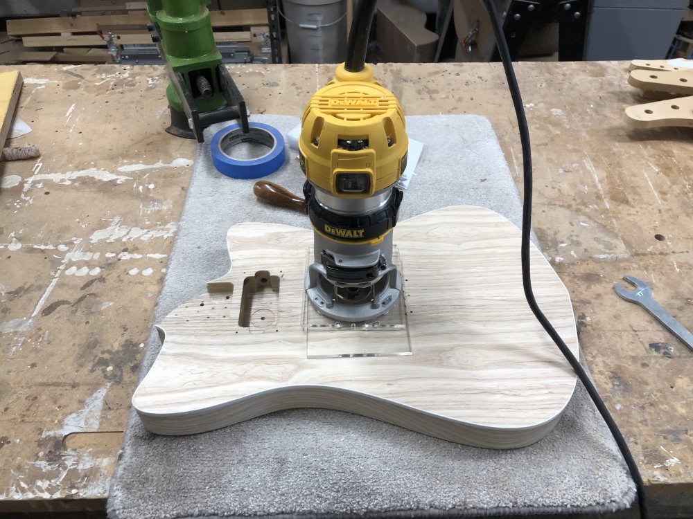 The guitar body sits with a palm-router over the bridge pickup-cavity.