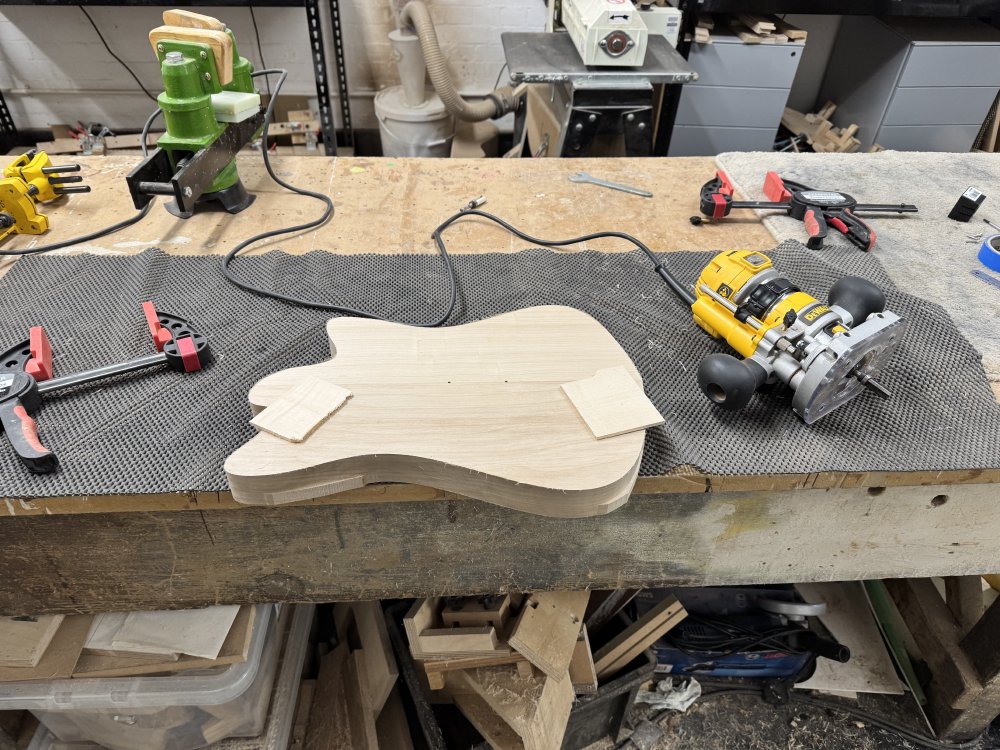 A photo of the body mostly cut out sat on the workbench, the template no longer needed having been removed. There's just a couple of sections on the lower half of the body where you can still see the rough cut from the band saw.