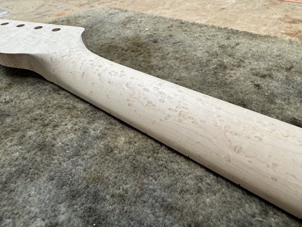 Another close up photo of the carved neck, showing the smooth transition around the headstock end.